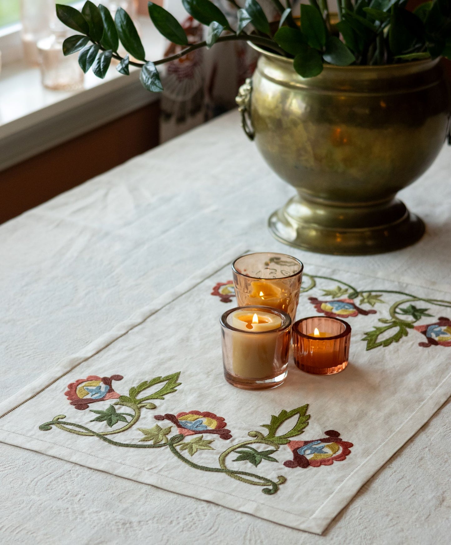 embroidery table runner kit with floral designs with brass urn with plant