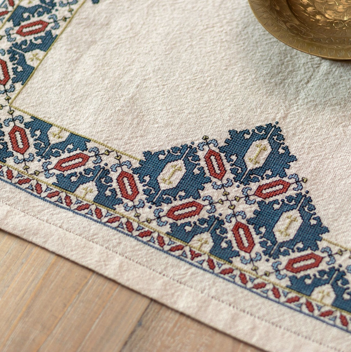 cross stitch folk embroidery textile with mulberry leaf pattern closeup