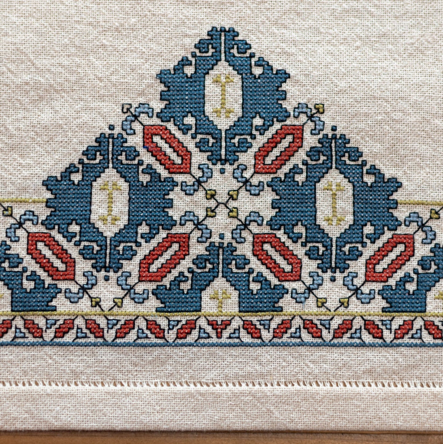 cross stitch folk embroidery textile with mulberry leaf pattern closeup