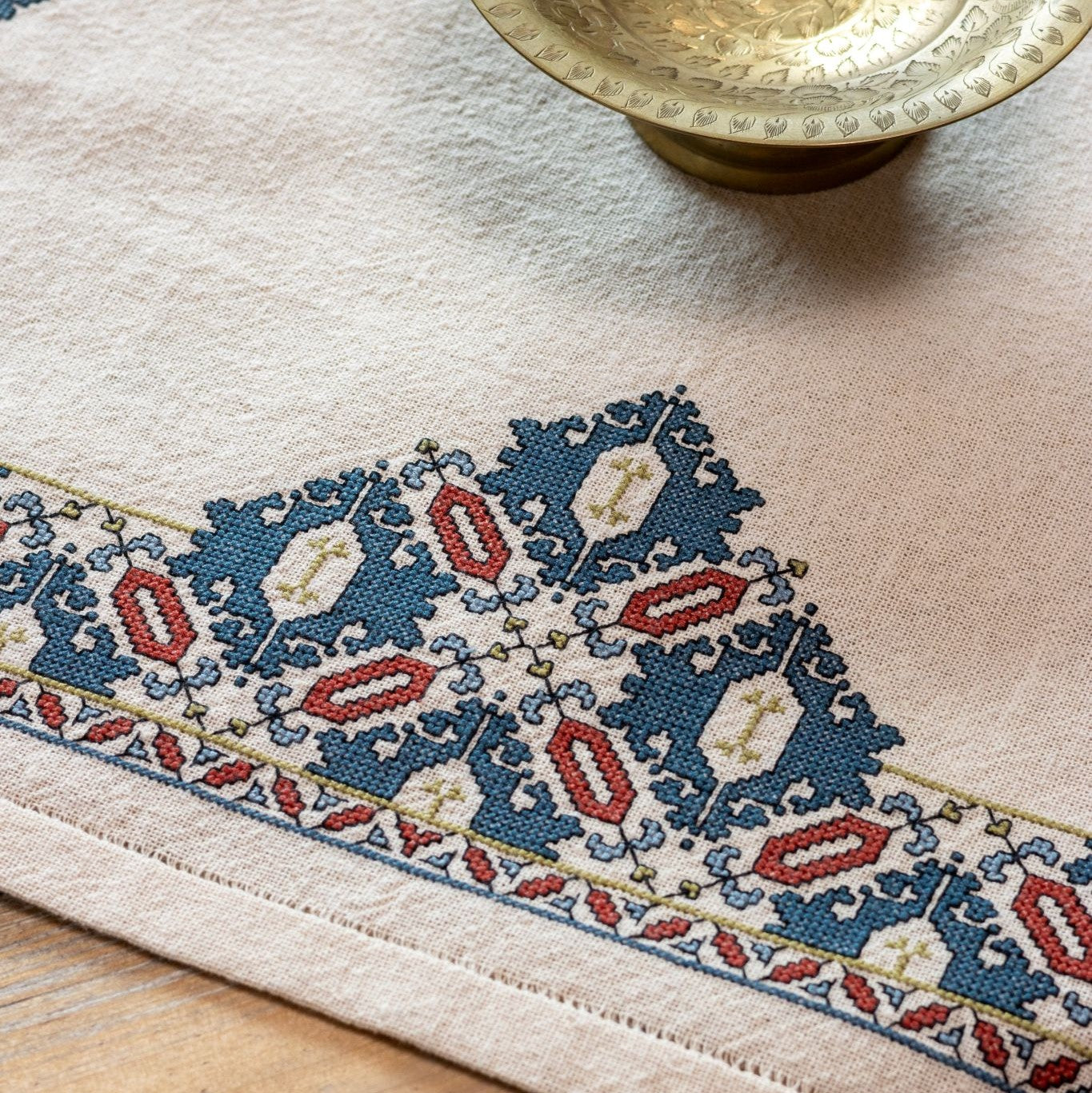 cross stitch folk embroidery textile with mulberry leaf pattern closeup