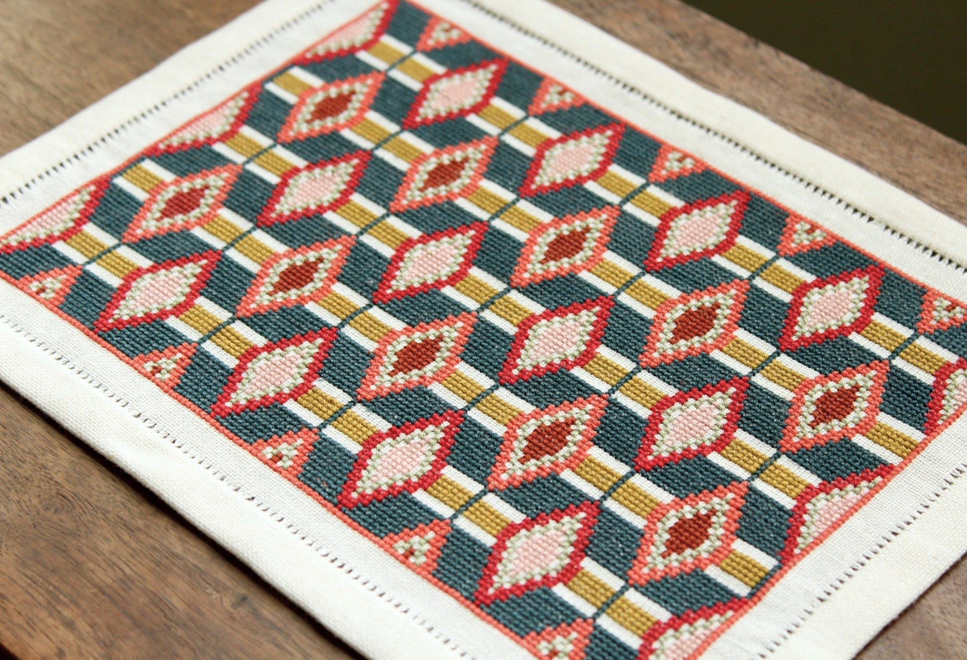 cross stitch folk embroidery table mat with repeating oval design