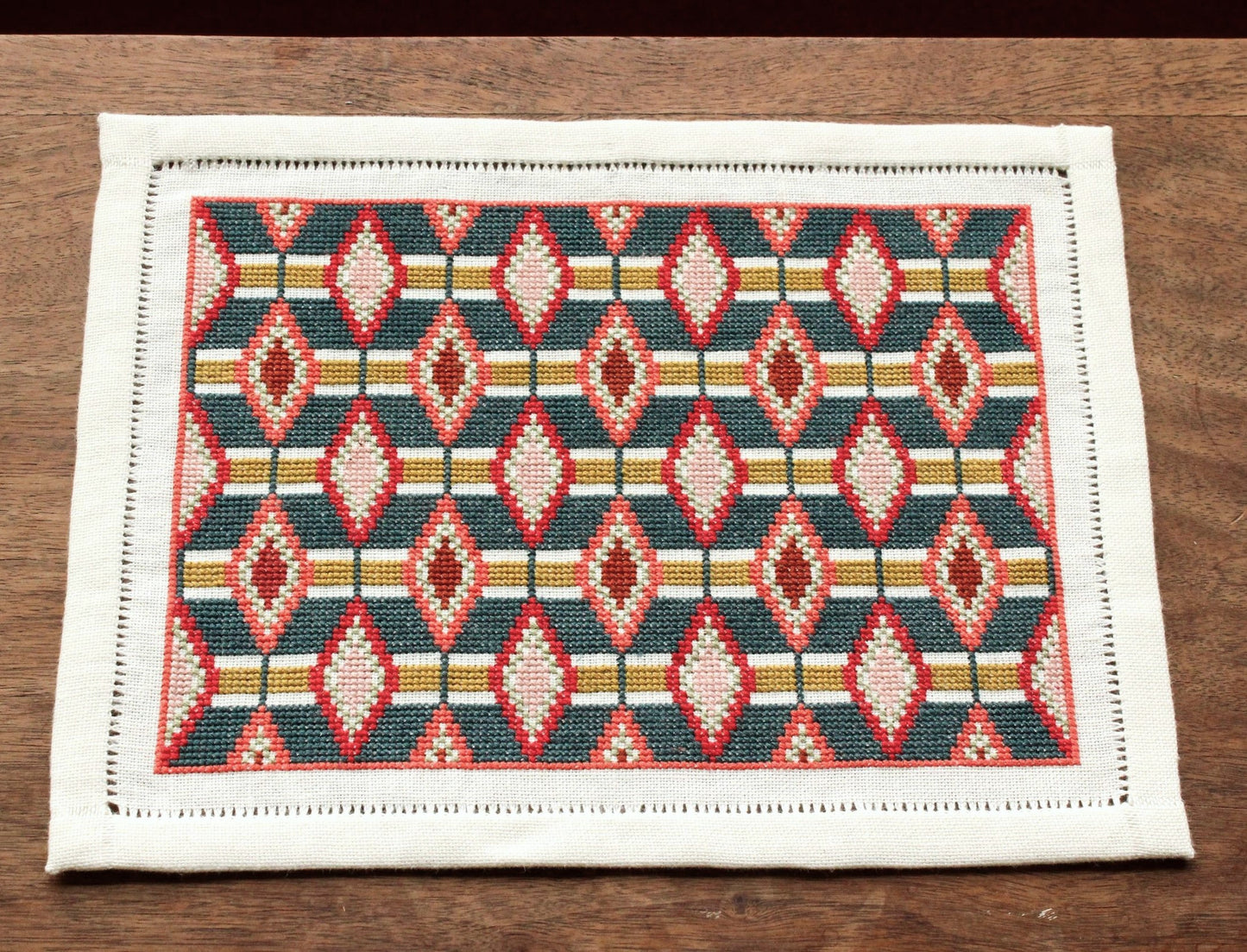 cross stitch folk embroidery table mat with repeating oval design