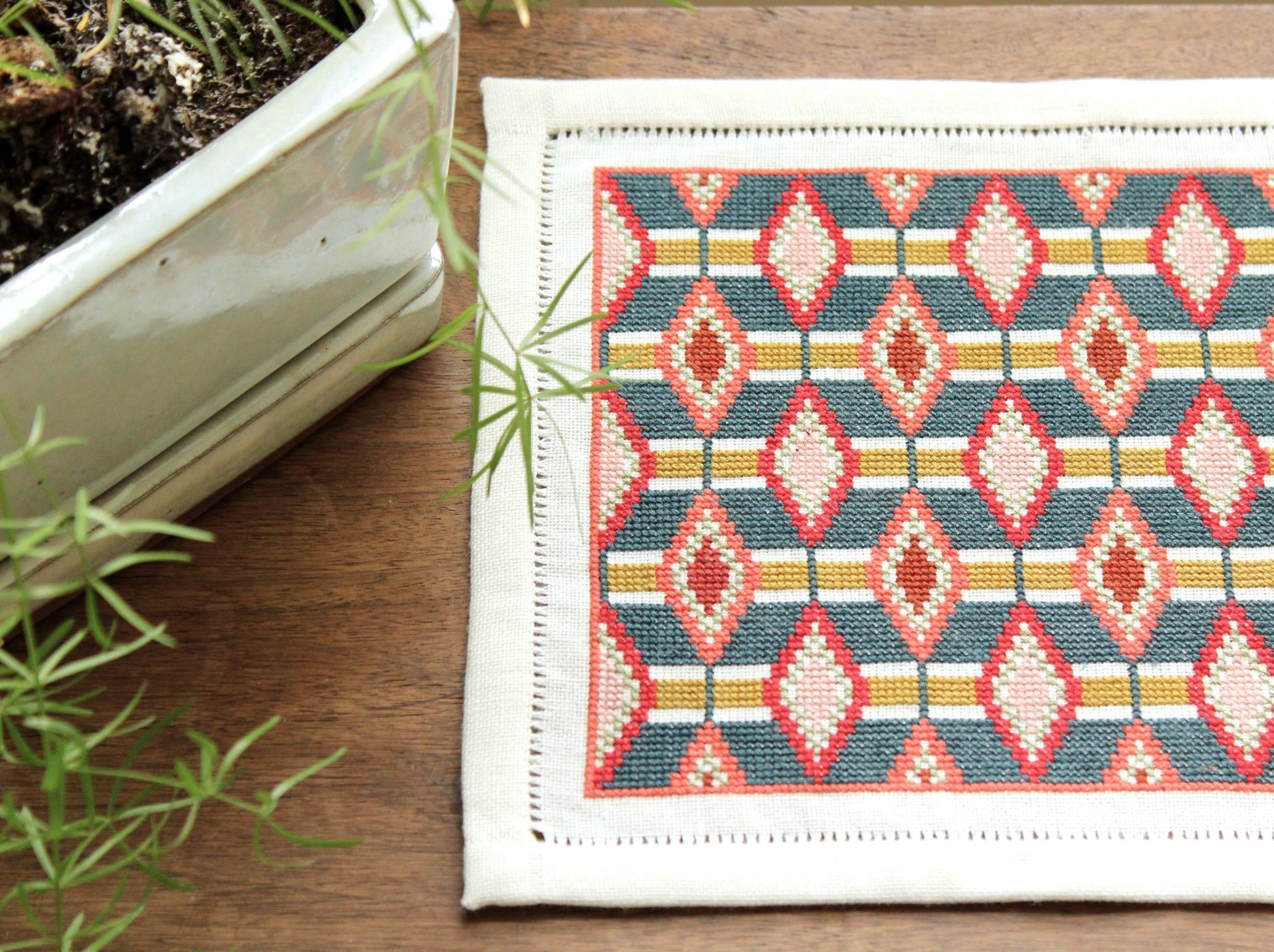 cross stitch folk embroidery table mat with repeating oval design