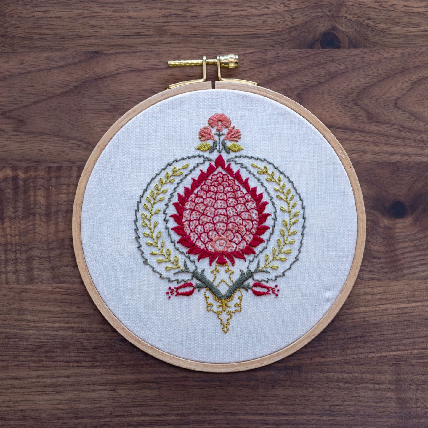 Embroidery hoop with floral design on a wooden surface