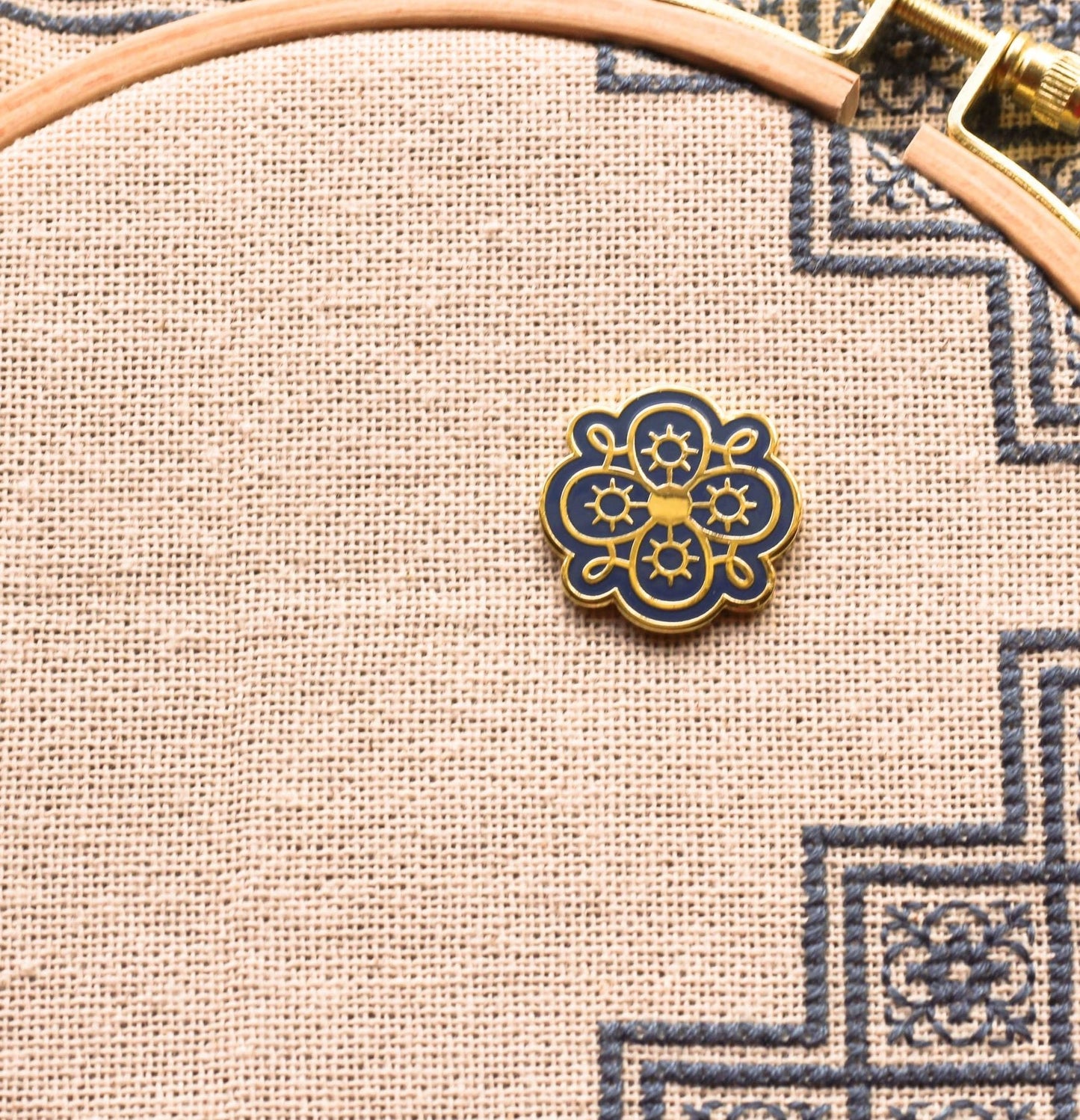 folk embroidery with embroidery needleminder in pumpkin seed design on blue background