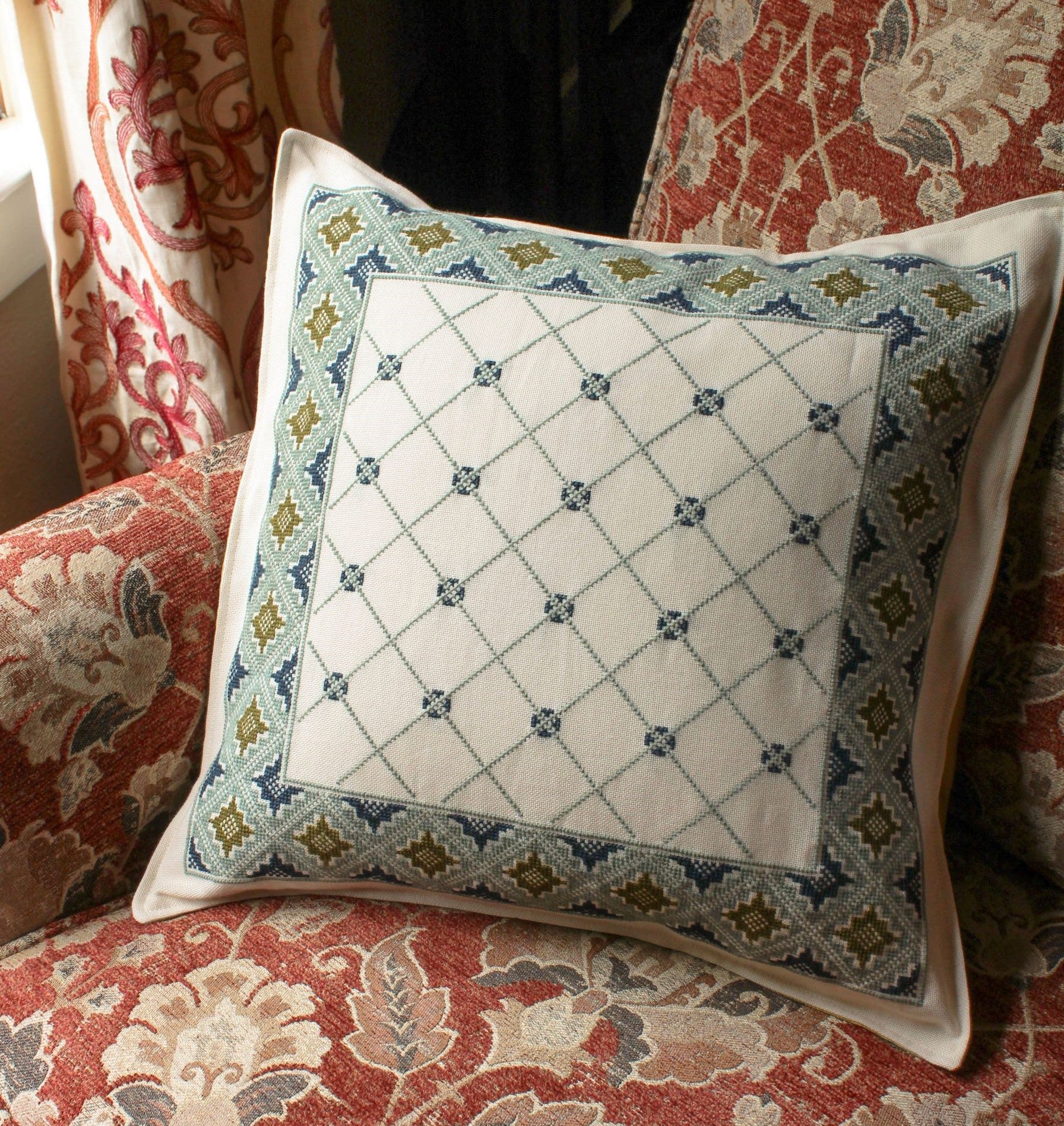 cross stitch folk embroidery cushion with repeating design in wool