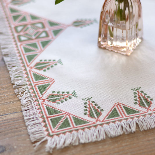 Greek cross stitch folk embroidery on table with plant