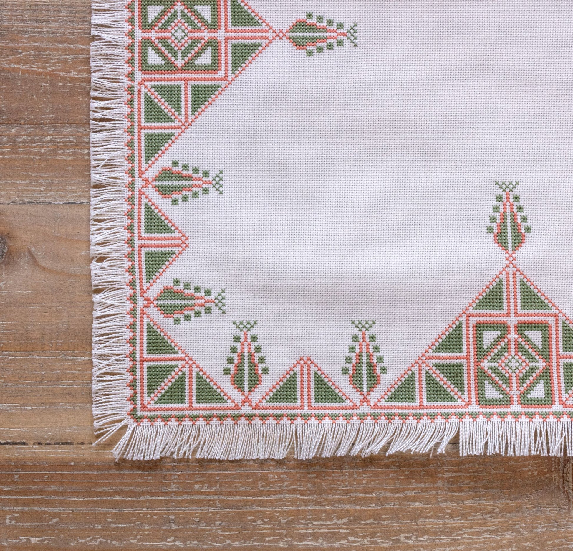 Greek cross stitch folk embroidery tree design on table with plant
