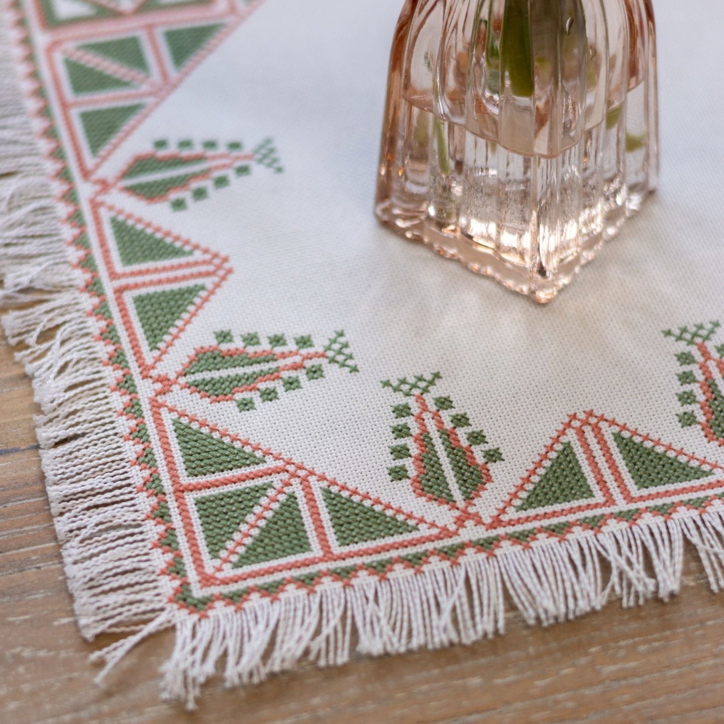 Greek cross stitch folk embroidery tree design on table with plant