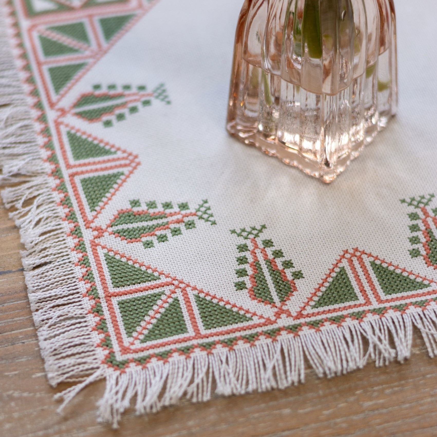 Greek cross stitch folk embroidery tree design on table with plant