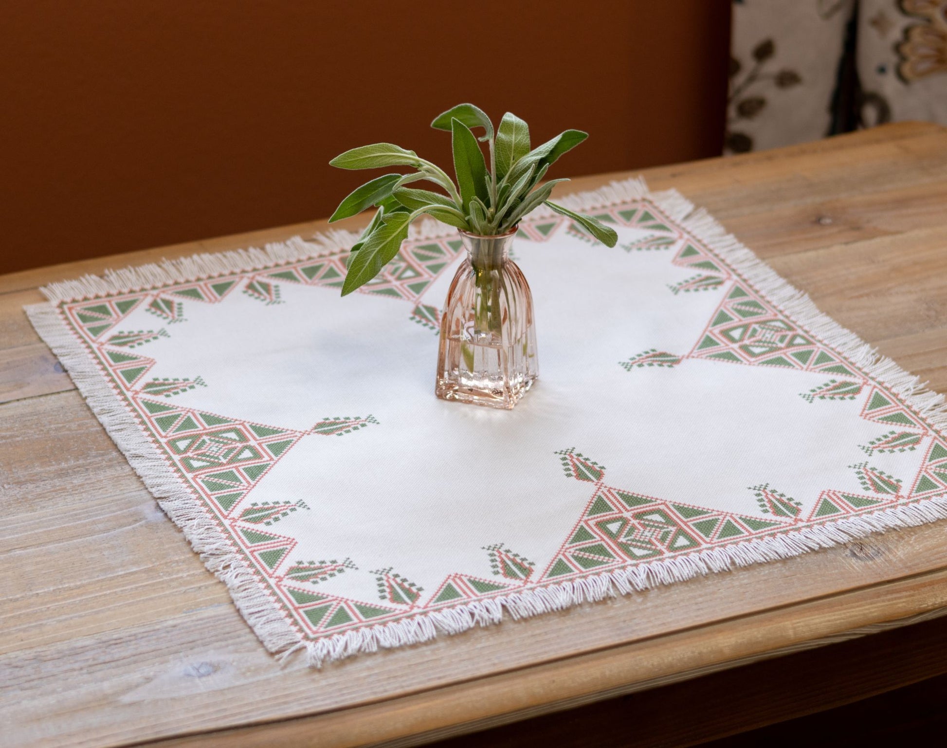 Greek cross stitch folk embroidery tree design on table with plant