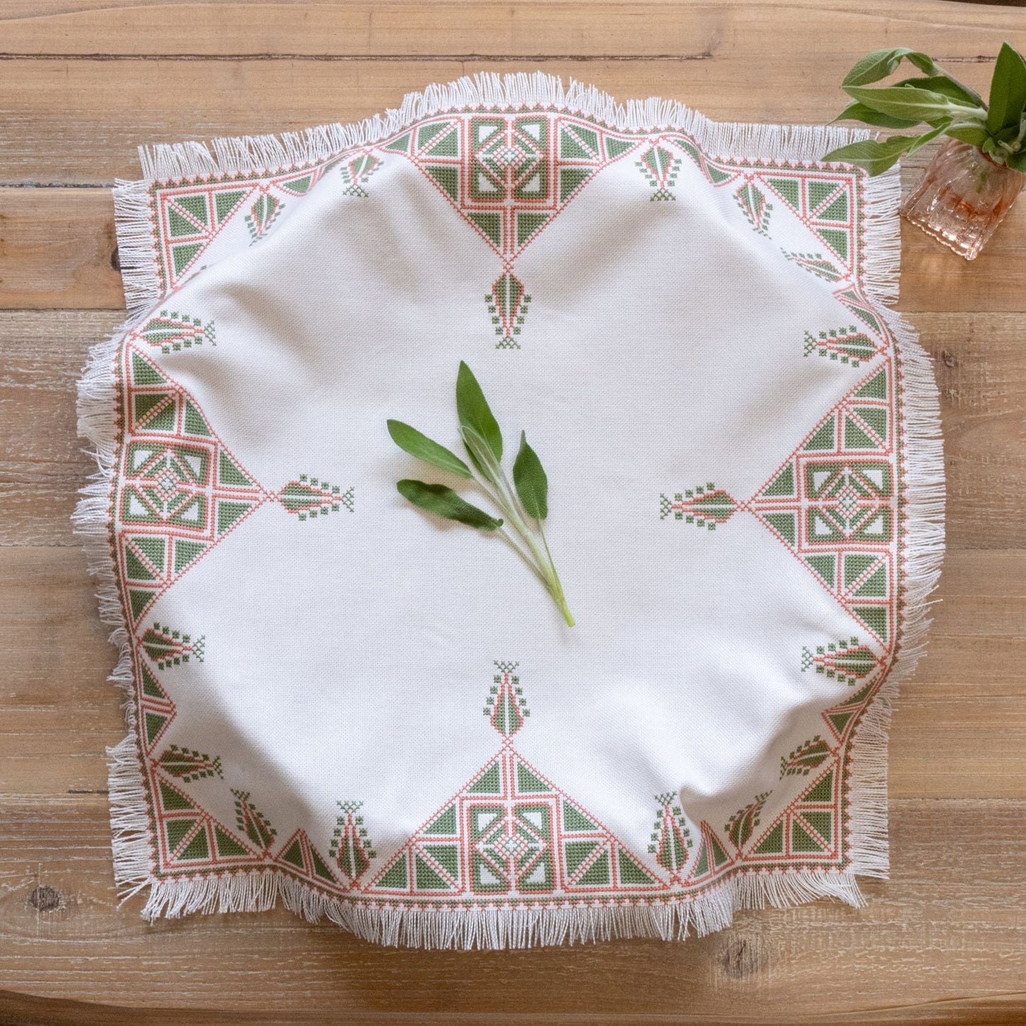 Greek cross stitch folk embroidery tree design on table with plant