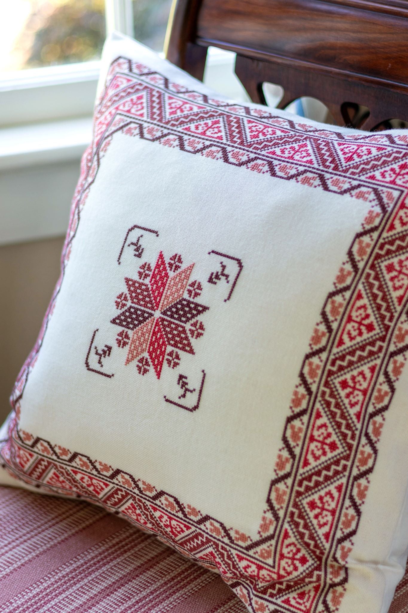 folk embroidery cushion with red border design