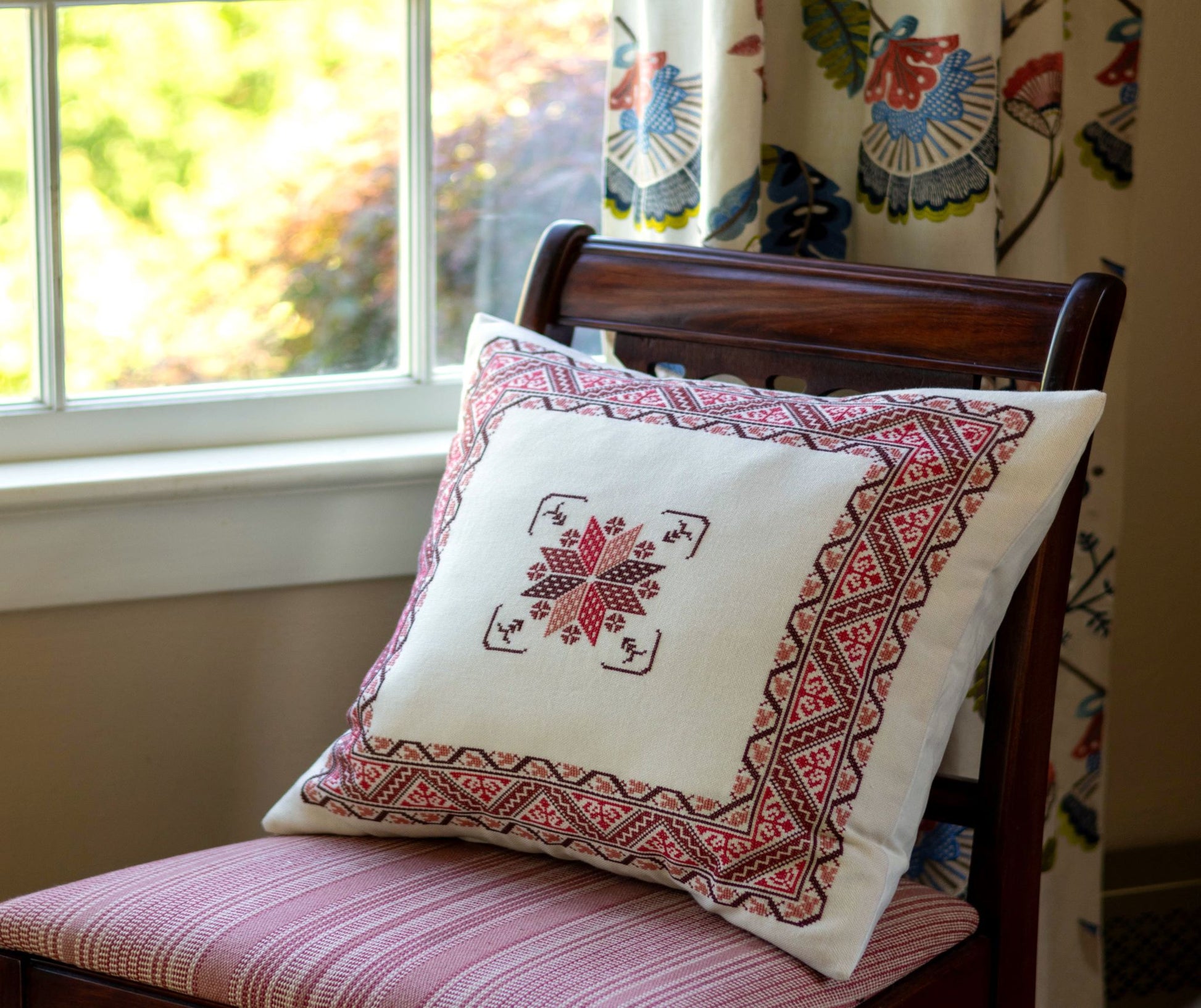 folk embroidery cushion with red border design